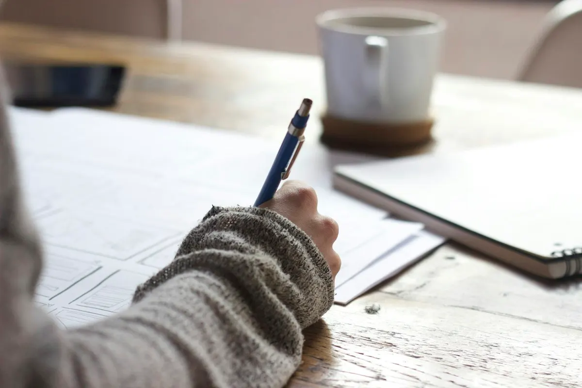 A notebook and hands at work, illustrating independent study